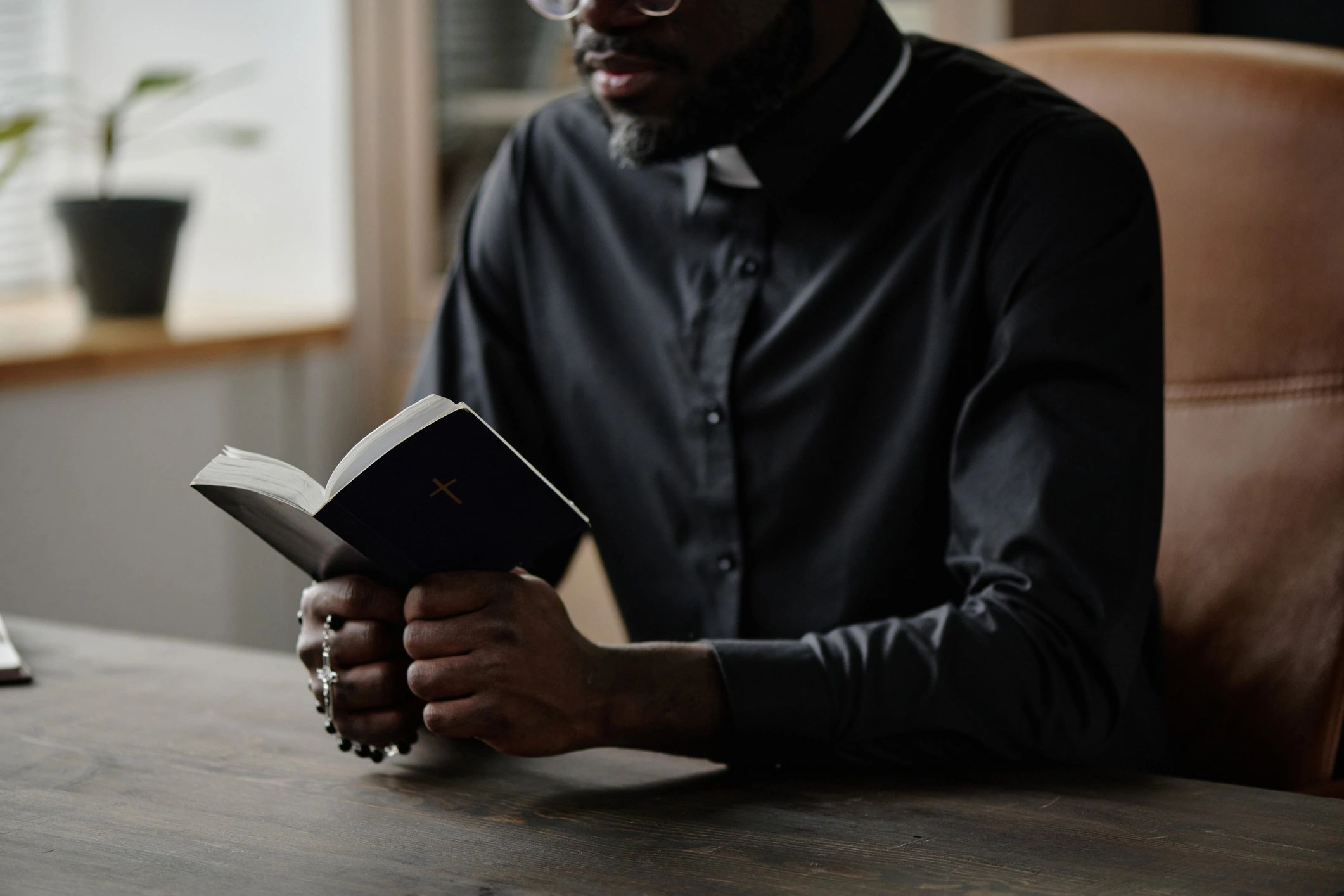 Hands holding a Bible in a quiet prayerful setting
